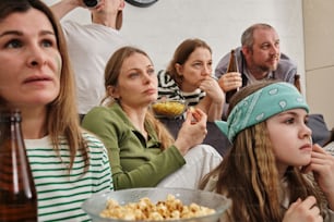 un groupe de personnes regardant un film et mangeant du maïs soufflé