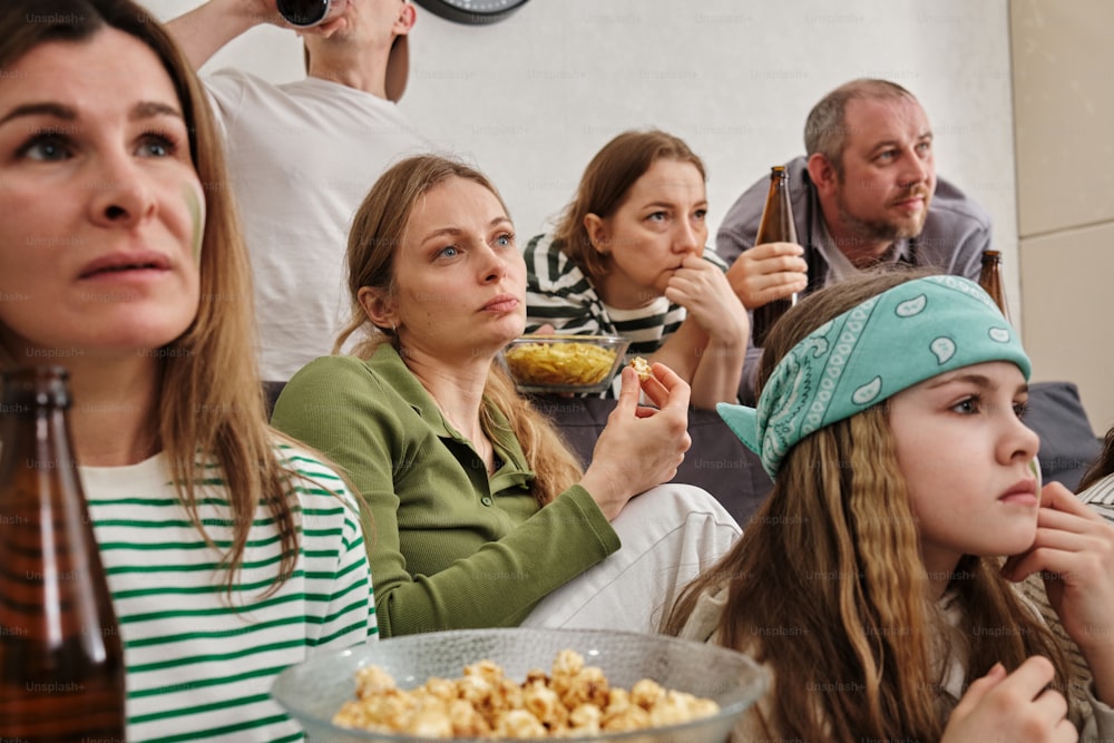 a group of people watching a movie and eating popcorn