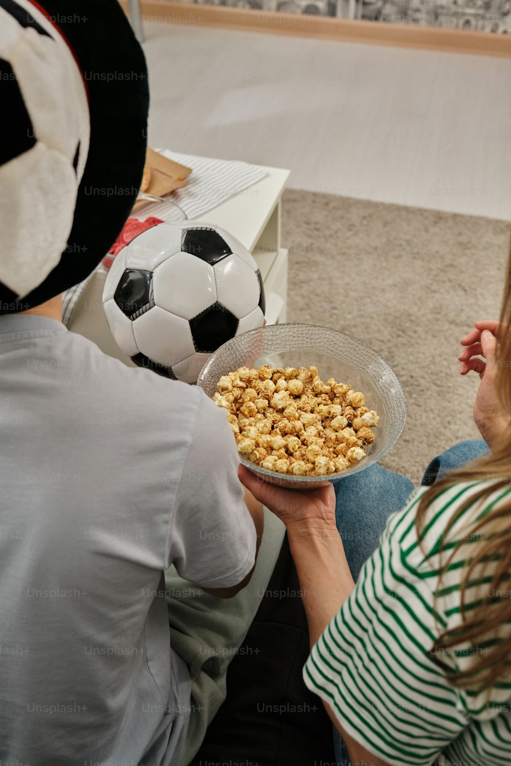 um homem e uma mulher sentados no chão segurando uma tigela de cereais
