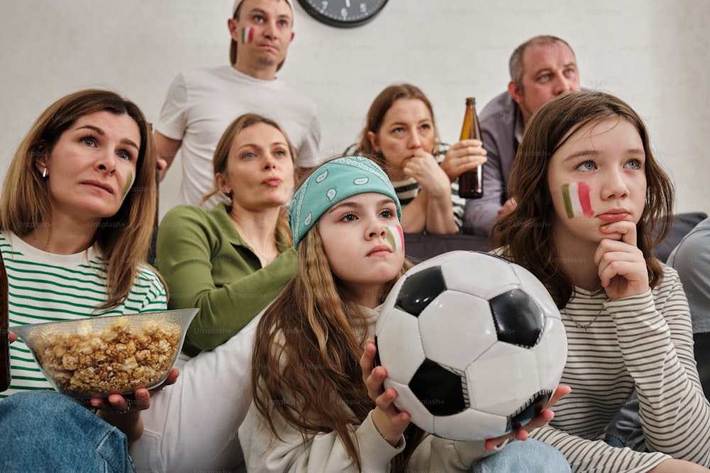 a group of people sitting on a couch with a soccer ball