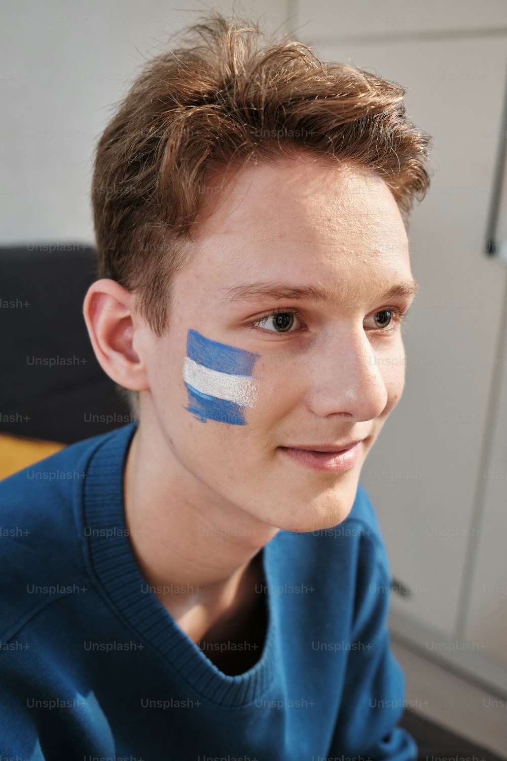 um jovem com uma bandeira pintada no rosto