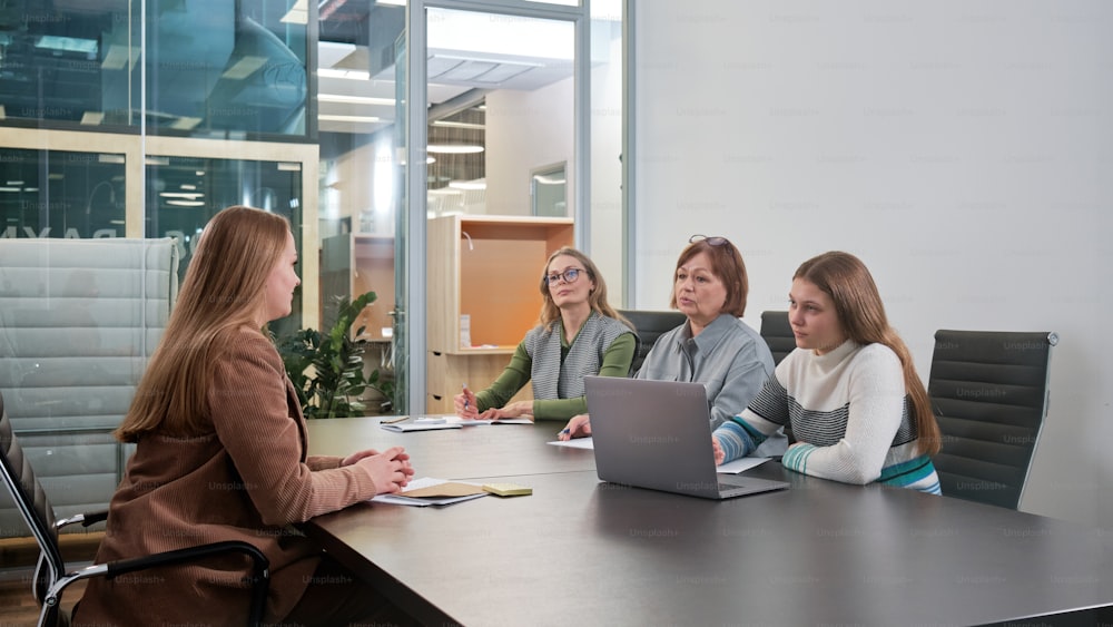 a group of women sitting around a conference table