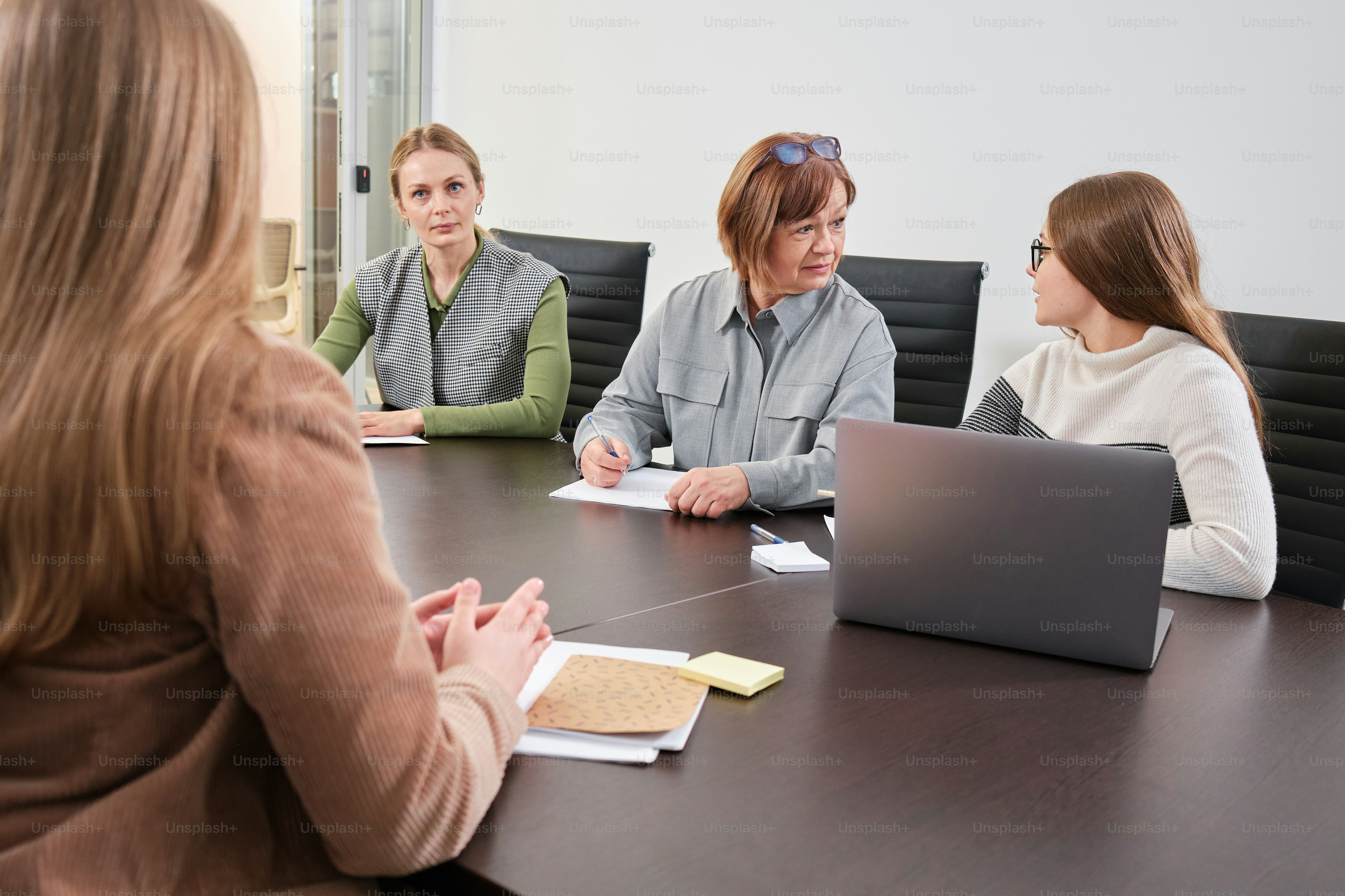 a group of women sitting around a conference table
