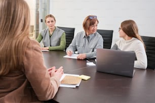 un groupe de femmes assises autour d’une table de conférence