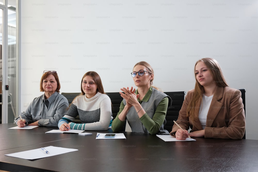 Un grupo de mujeres sentadas alrededor de una mesa de conferencias