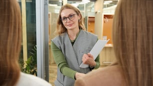 Une femme portant des lunettes tient un morceau de papier