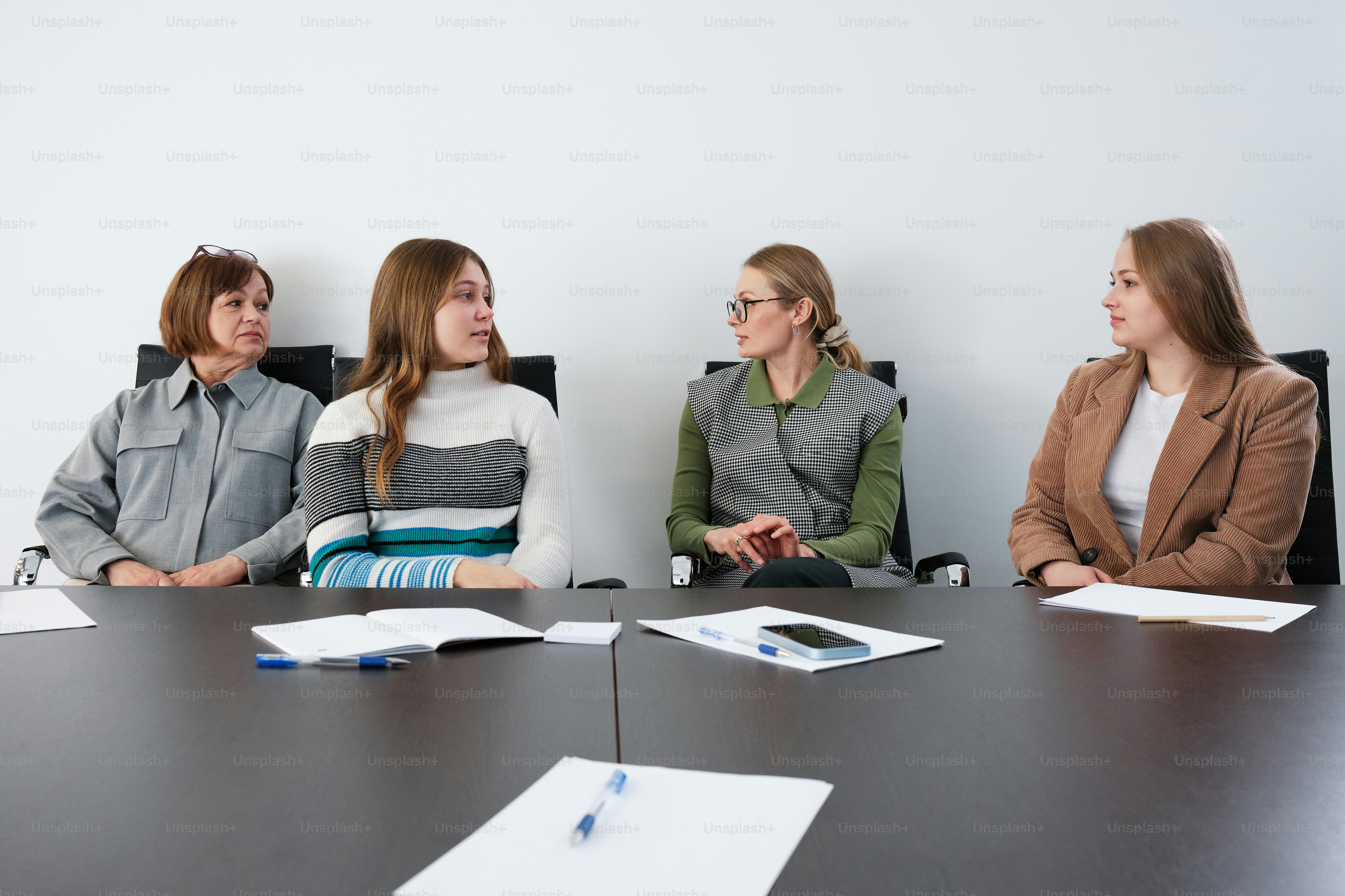 eine Gruppe von Menschen, die um einen Konferenztisch sitzen