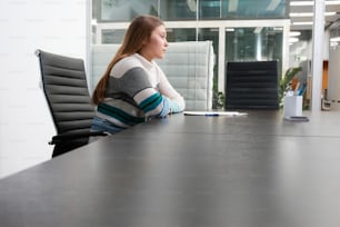 a woman sitting at a table in an office