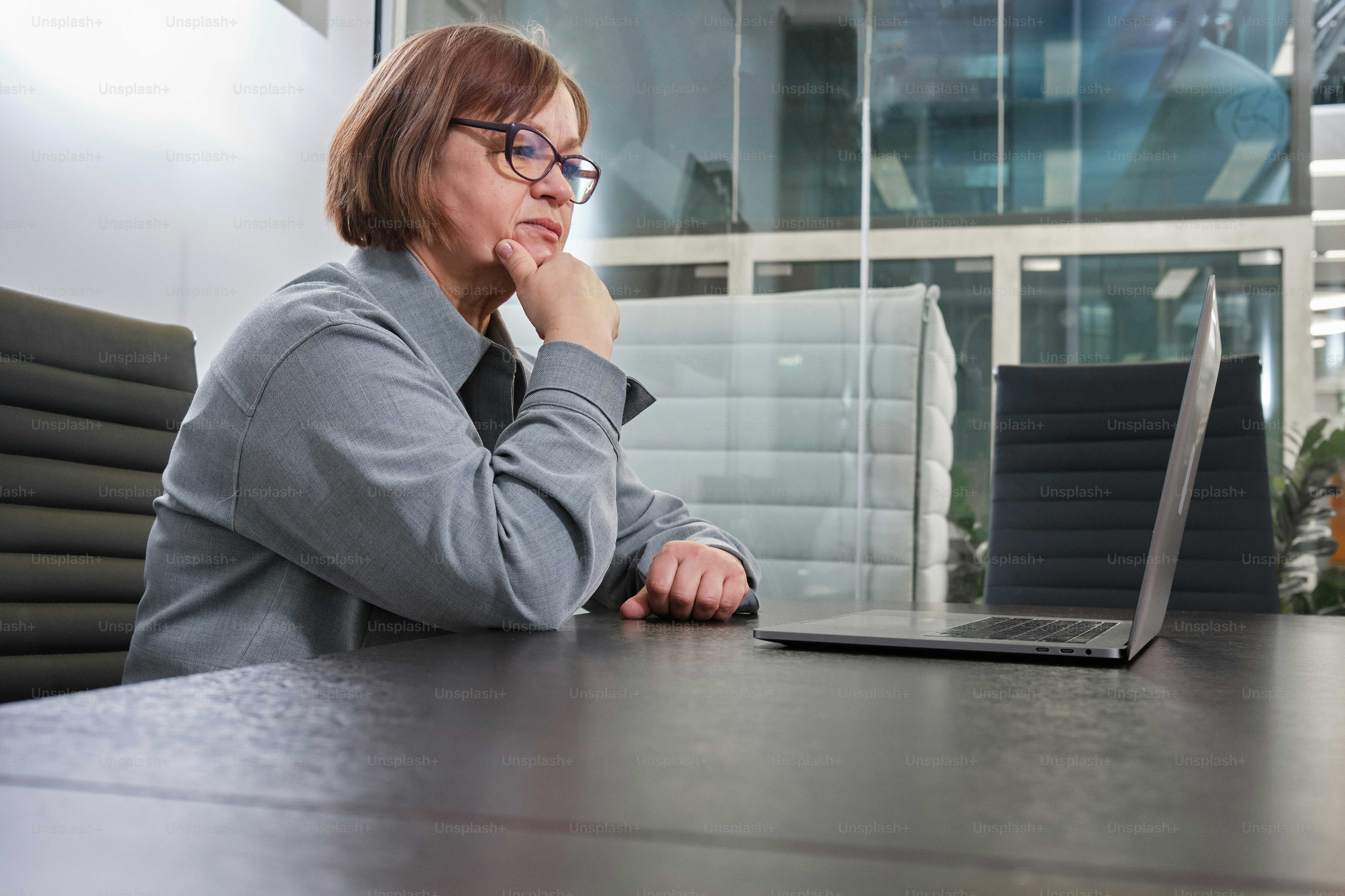 Eine Frau sitzt an einem Tisch mit einem Laptop vor sich