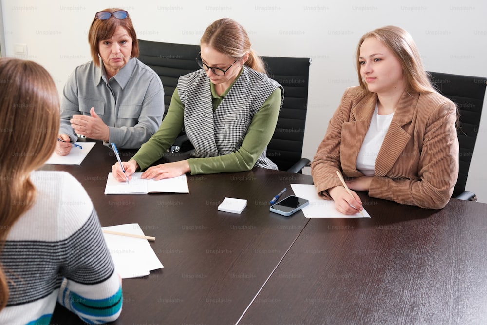 Un gruppo di donne sedute attorno a un tavolo da conferenza