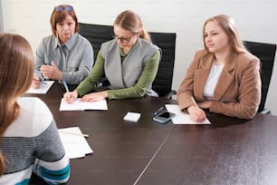 a group of women sitting around a conference table