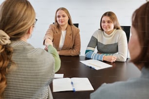 Eine Gruppe von Frauen, die an einem Tisch sitzen und sich unterhalten