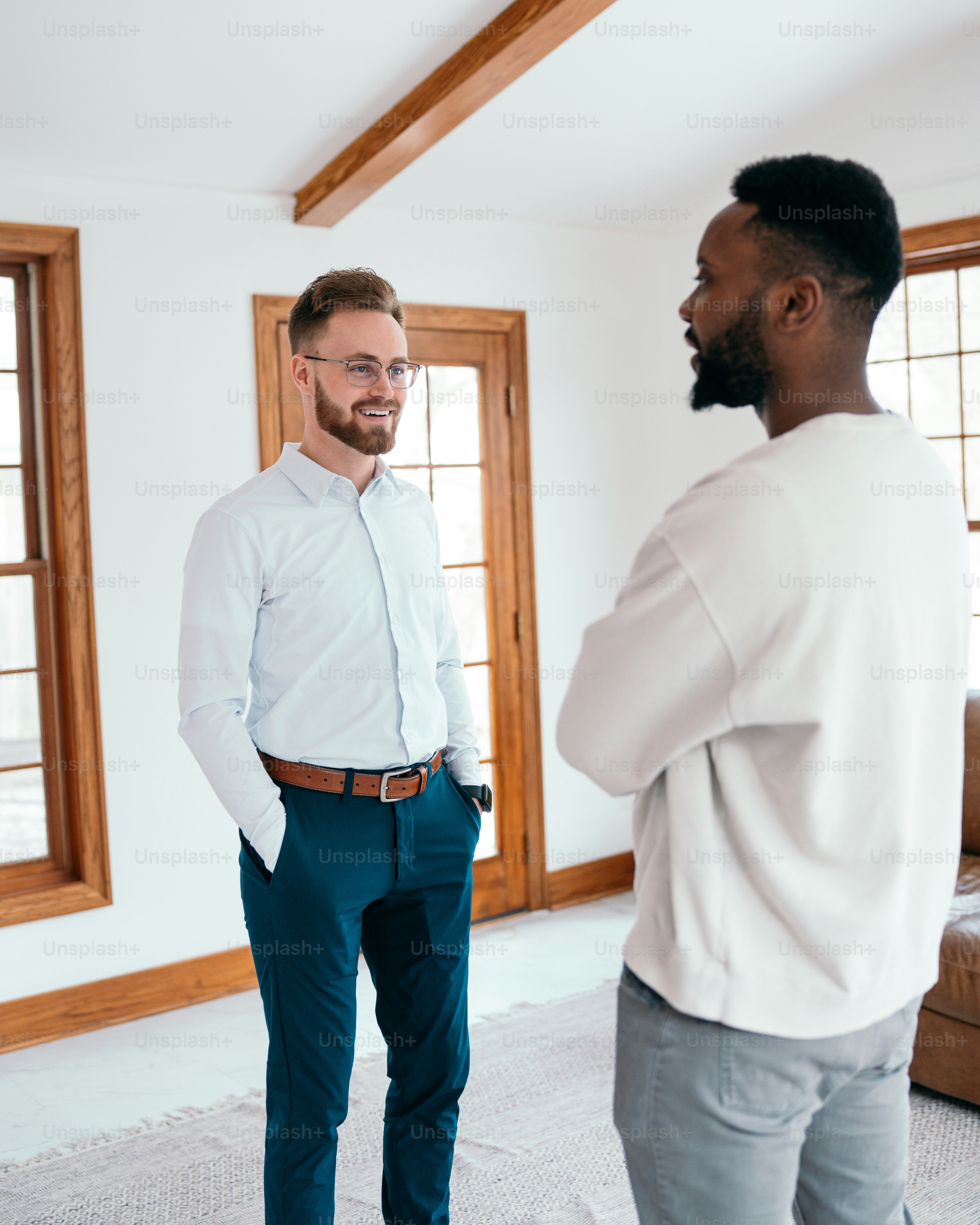 a man standing next to another man in a living room
