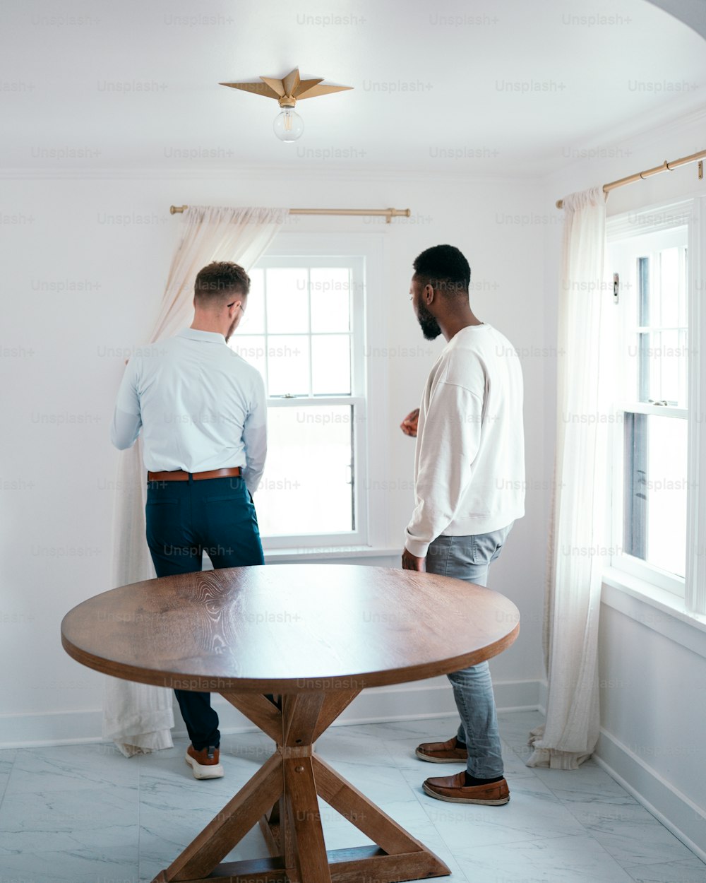 a couple of men standing around a wooden table