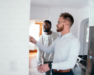 two men standing in a kitchen talking to each other