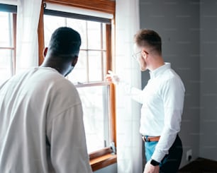 Ein Mann im weißen Hemd schaut aus dem Fenster