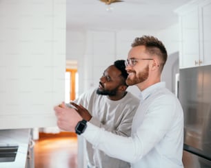 a couple of men standing next to each other in a kitchen