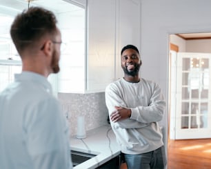 a man standing in a kitchen with his arms crossed