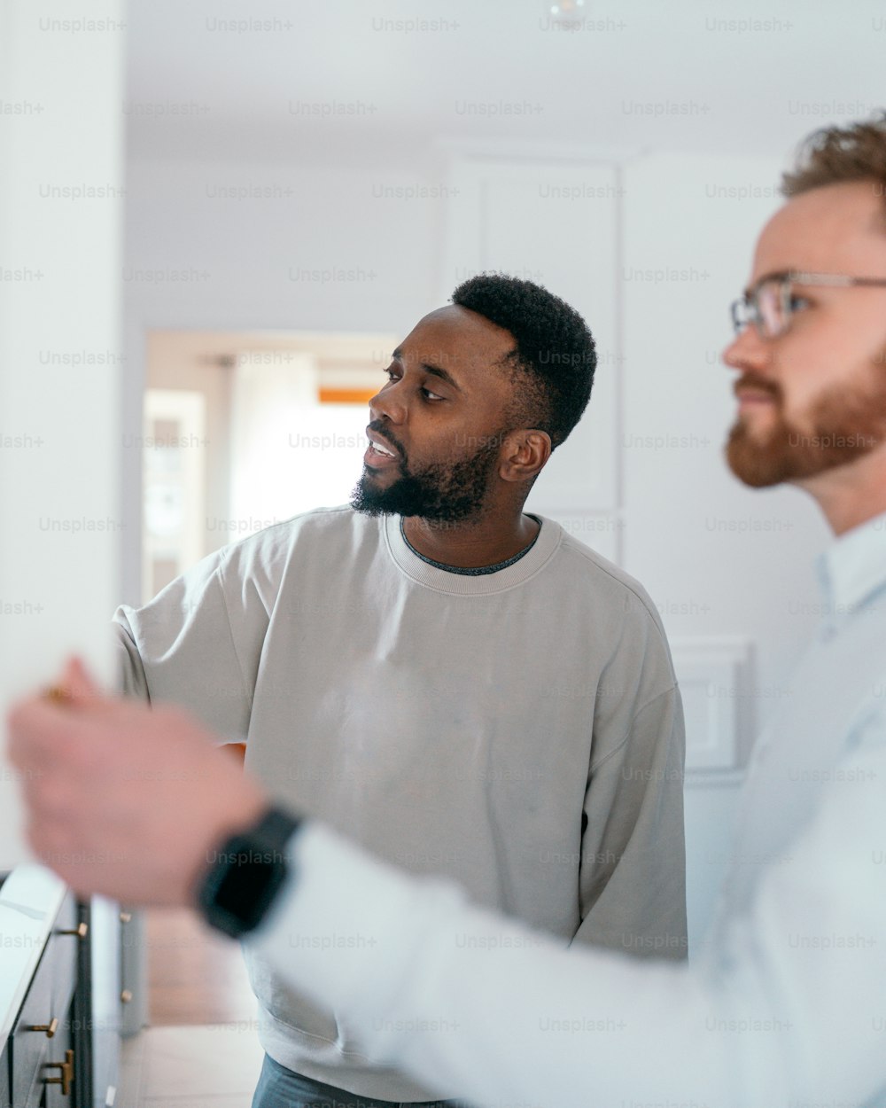 two men standing in a kitchen looking at each other