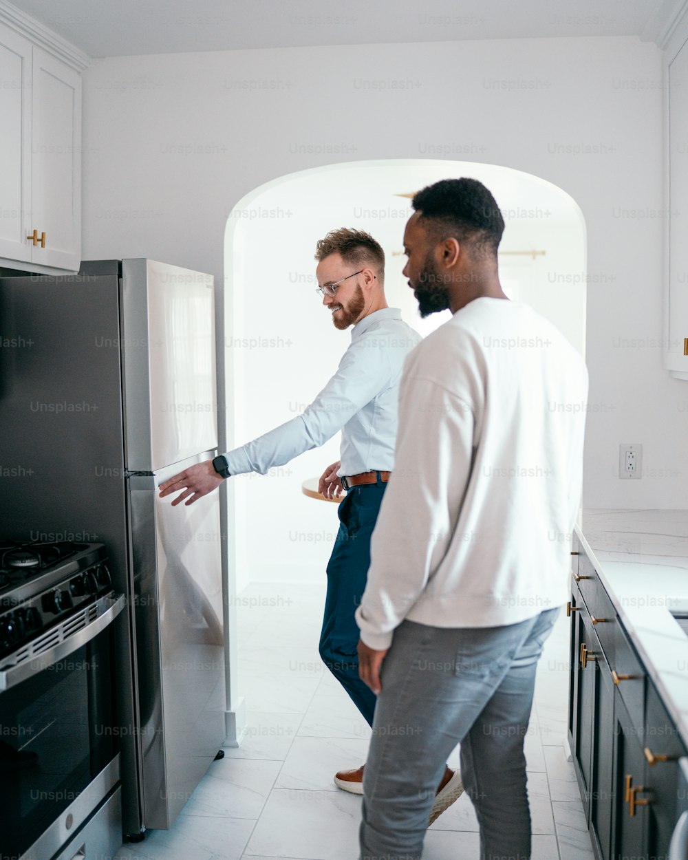 a couple of men standing next to each other in a kitchen