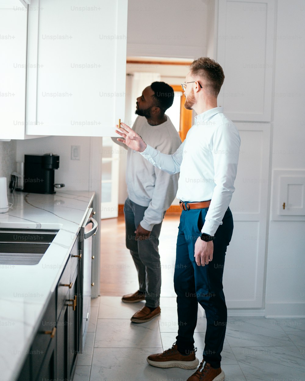 a couple of men standing in a kitchen