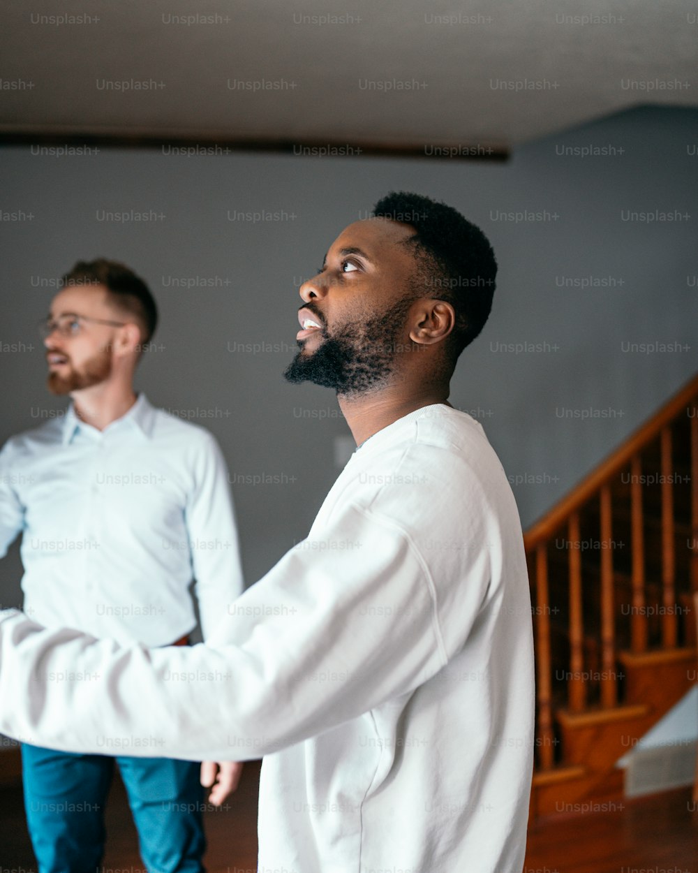 a man standing next to another man in a room