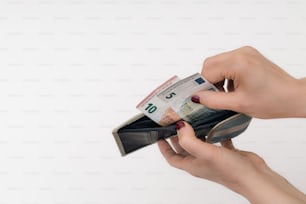 a person holding a wallet with a note sticking out of it