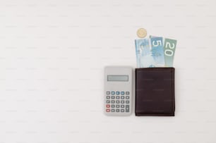una calculadora y una billetera sentadas una al lado de la otra