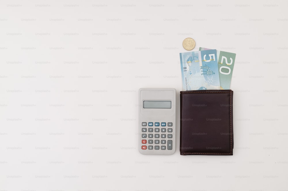una calculadora y una billetera sentadas una al lado de la otra