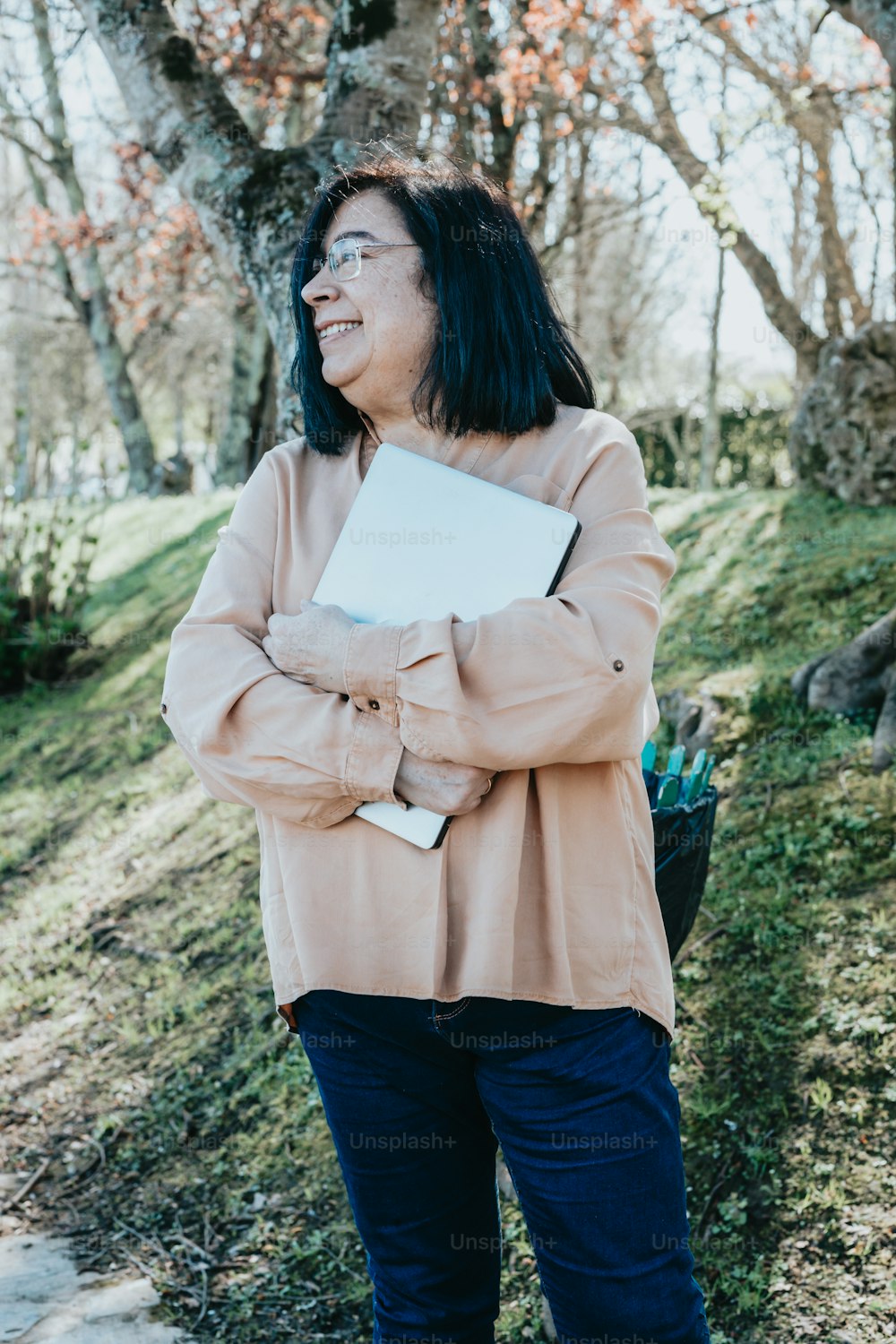 Una donna in piedi in un campo con in mano un libro