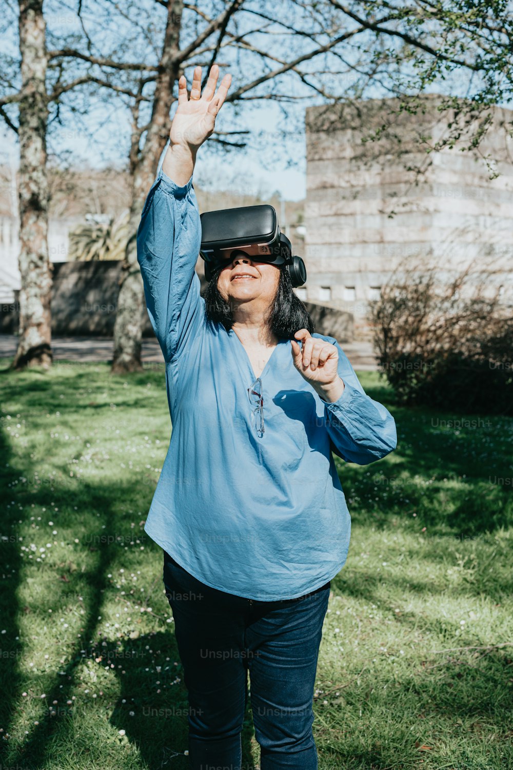a woman standing in the grass wearing a virtual reality headset