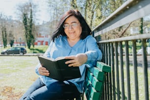 una donna seduta su una panchina che legge un libro