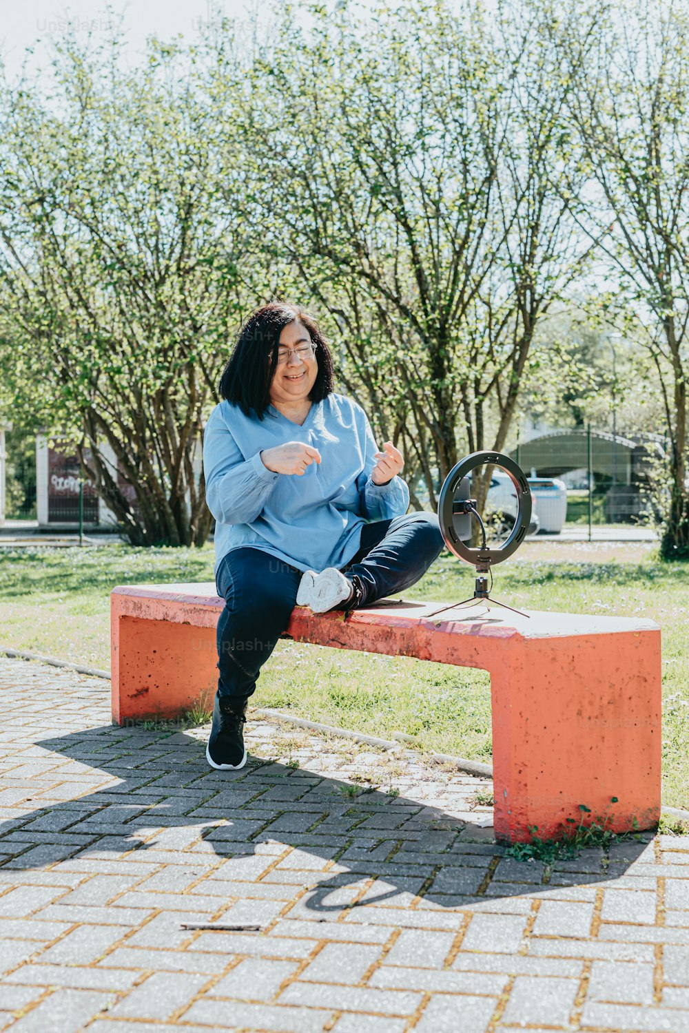 a woman sitting on a bench with a fan