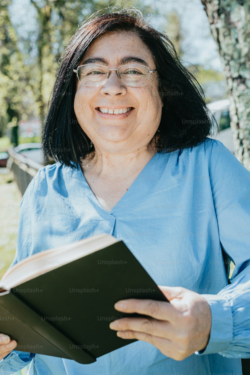 a woman in a blue shirt is holding a book
