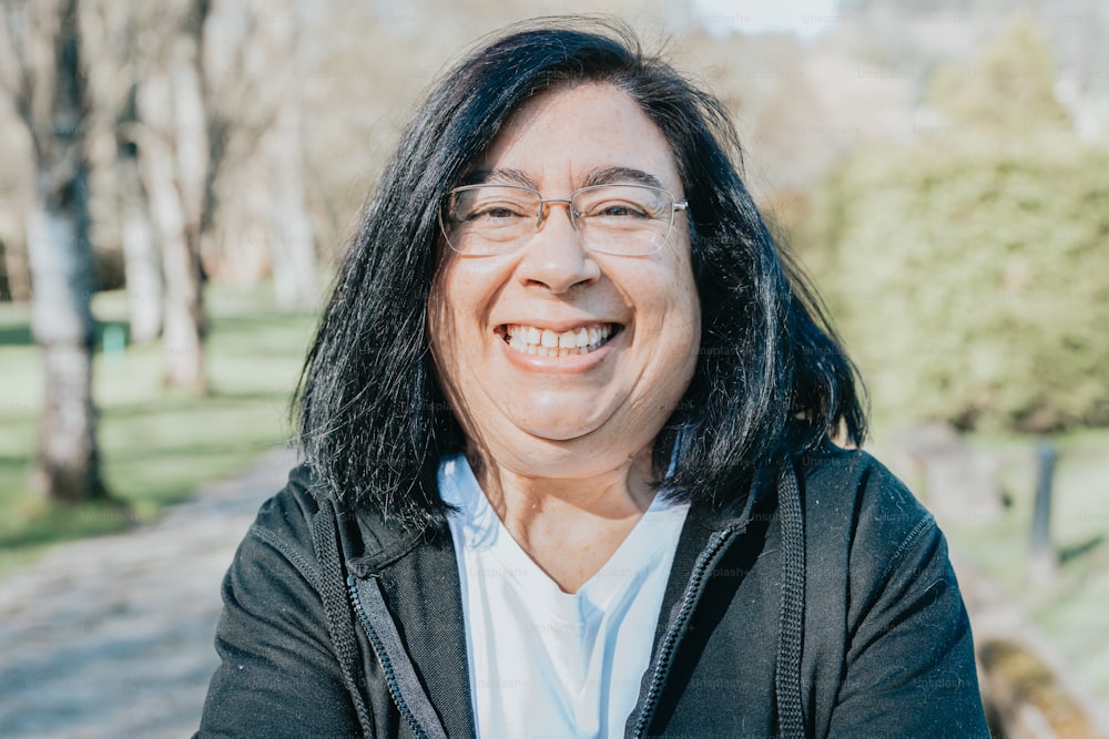 a woman with glasses smiling for the camera