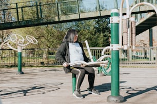 a woman sitting on a bench reading a newspaper