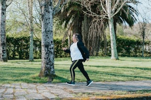 a woman running in a park with trees in the background