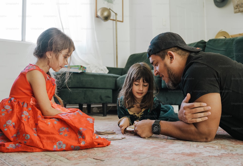 a man and two little girls sitting on the floor