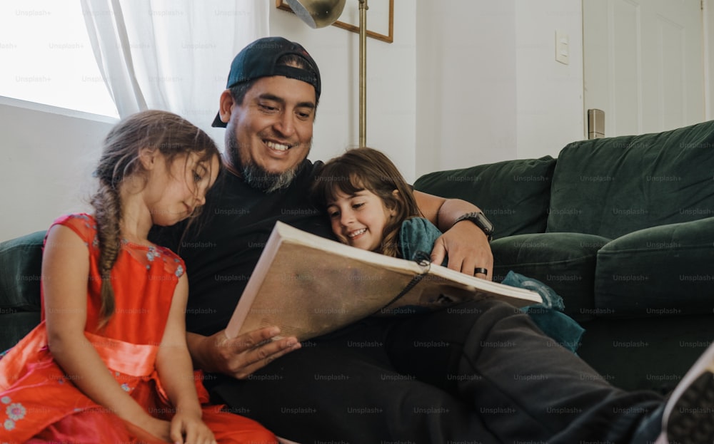 a man sitting on a couch with two little girls