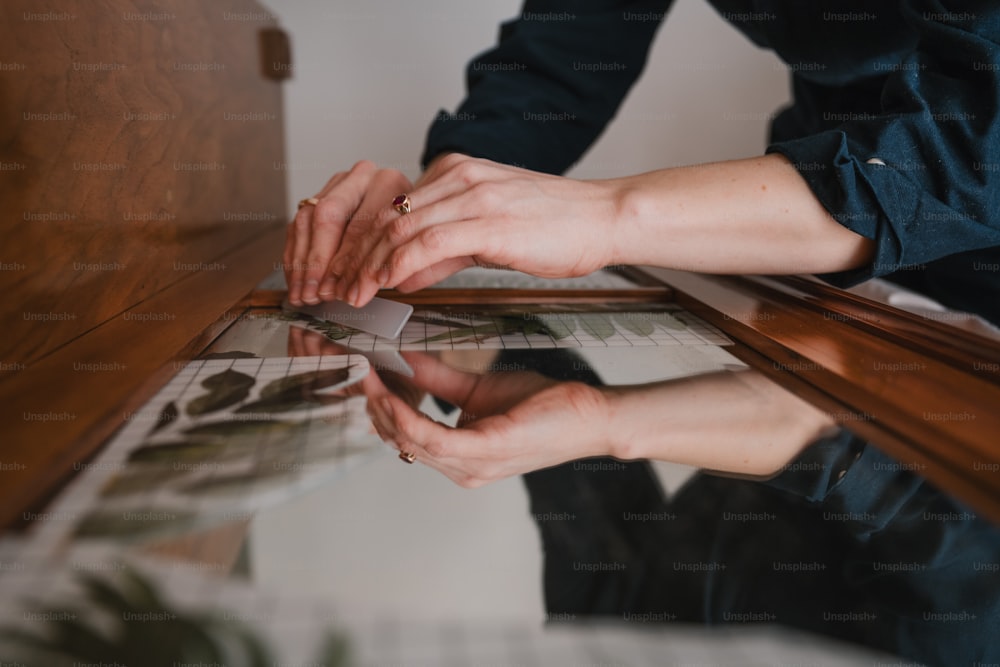 a person holding a piece of paper on top of a table