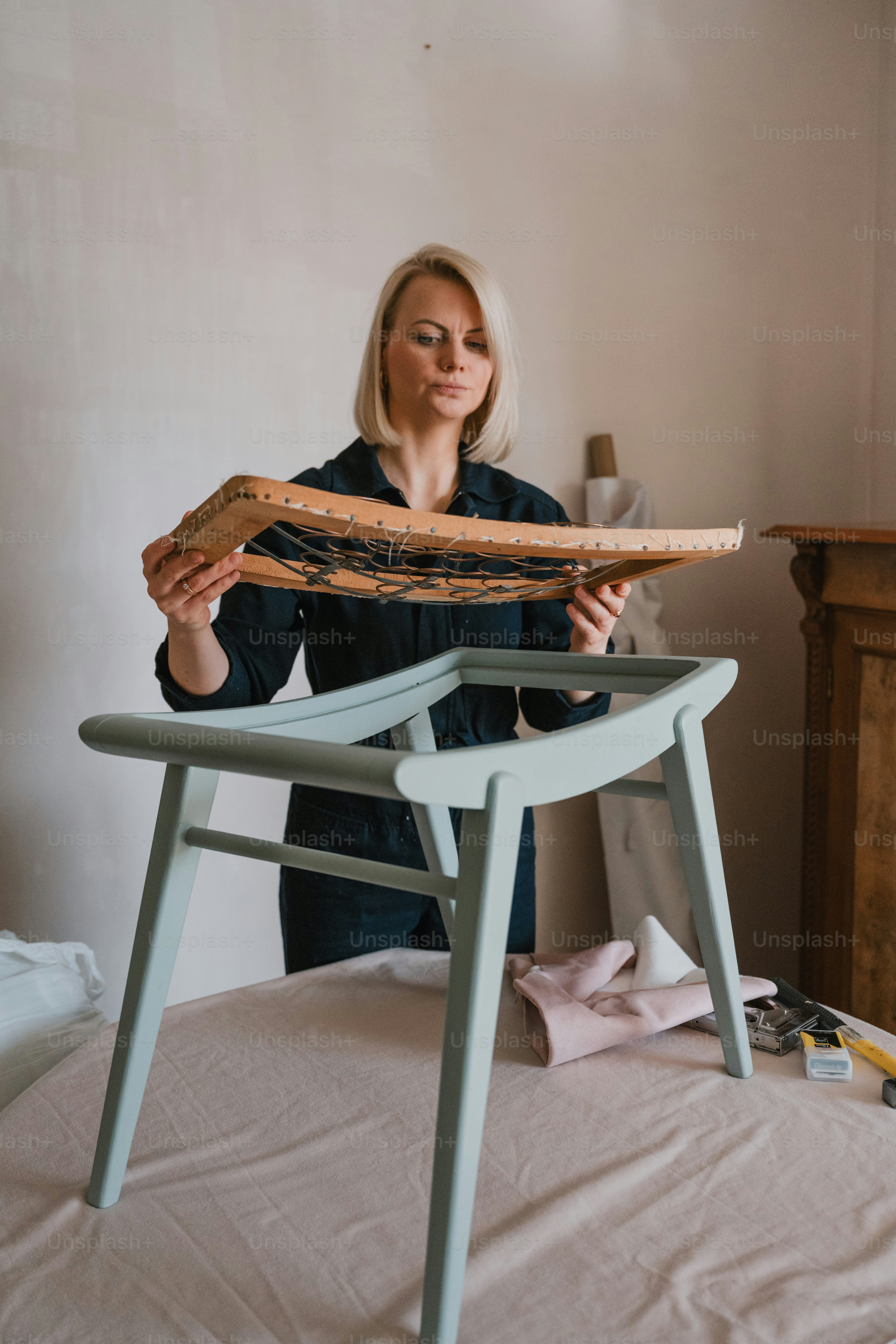 a woman holding a piece of bread on top of a chair