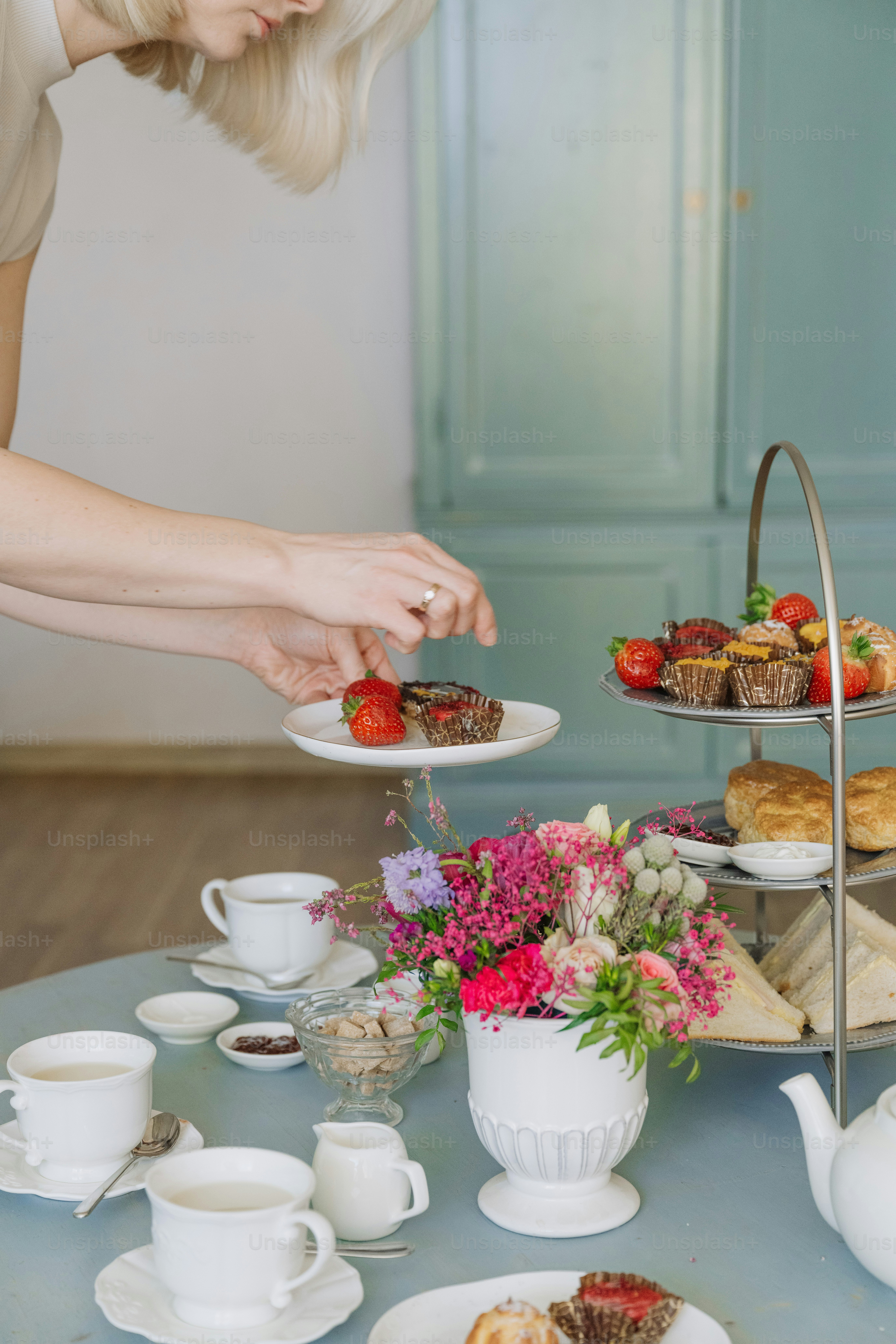 a woman picking up a piece of cake on a plate