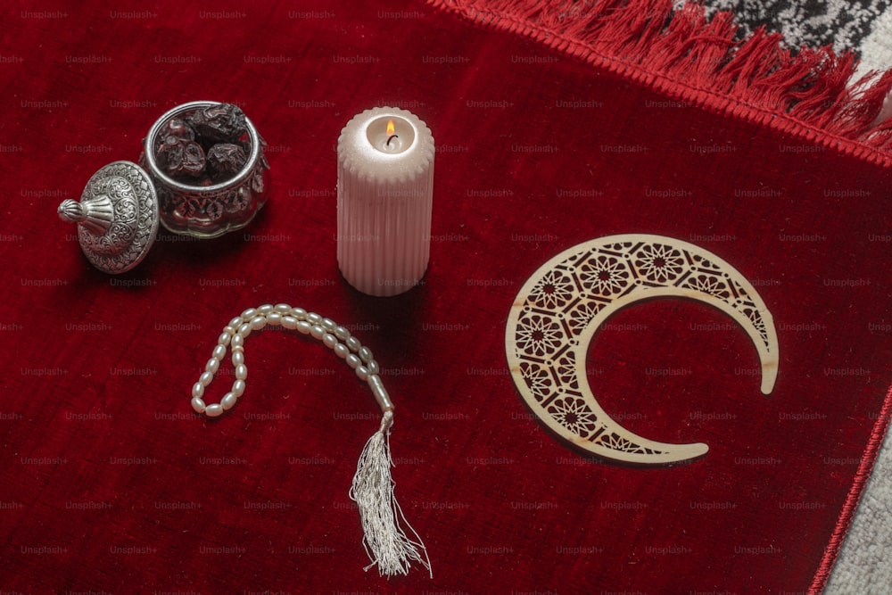 una alfombra roja con una vela y otros artículos