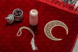 a red rug with a candle and other items on it