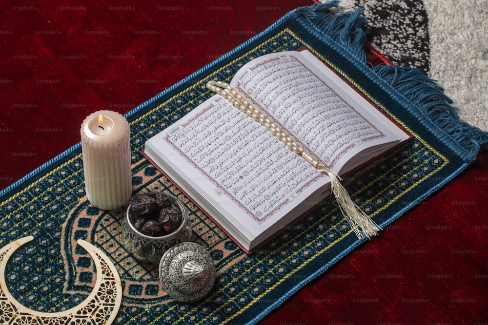 Ein offenes Buch und eine Kerze auf einem Teppich