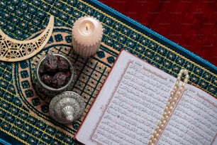 Ein offenes Buch und eine Kerze auf einem Teppich