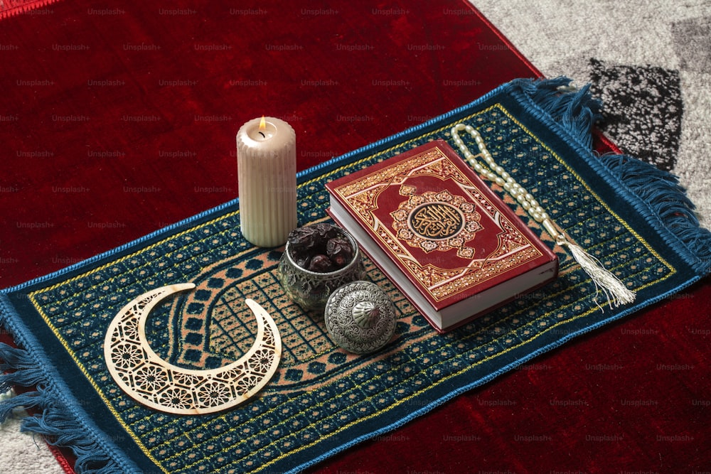 uma vela e um livro em um tapete