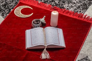 Un libro abierto en una alfombra con una vela y otros artículos