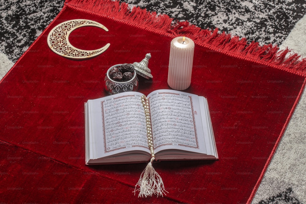 an open book on a rug with a candle and other items