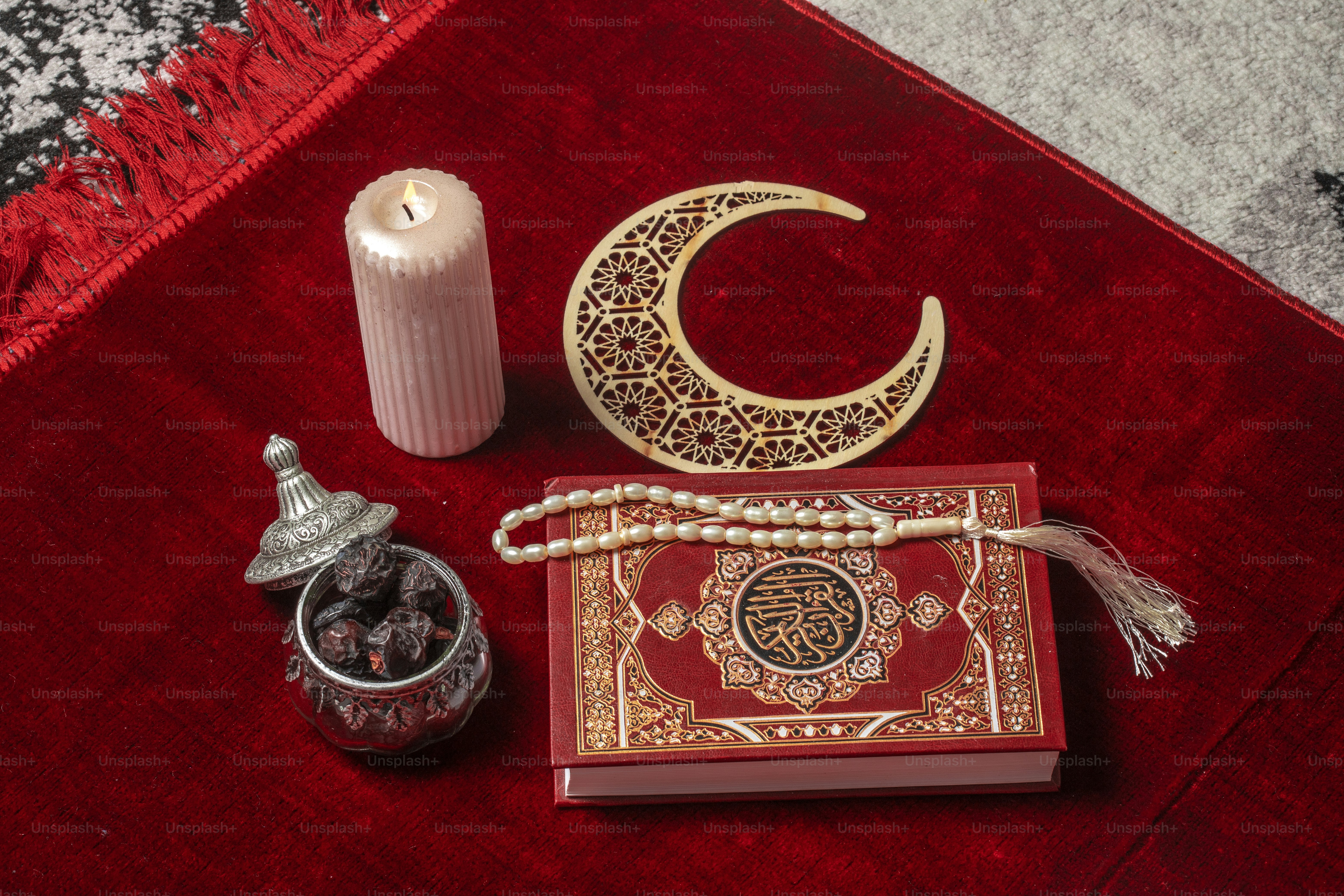 a red carpet with a candle, a book, a candle holder, and a
